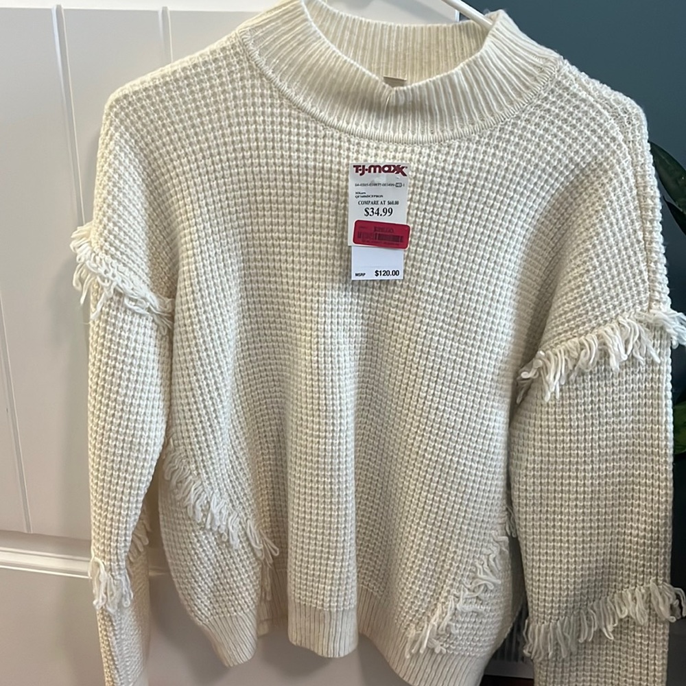Women’s cream sweater fits like medium.